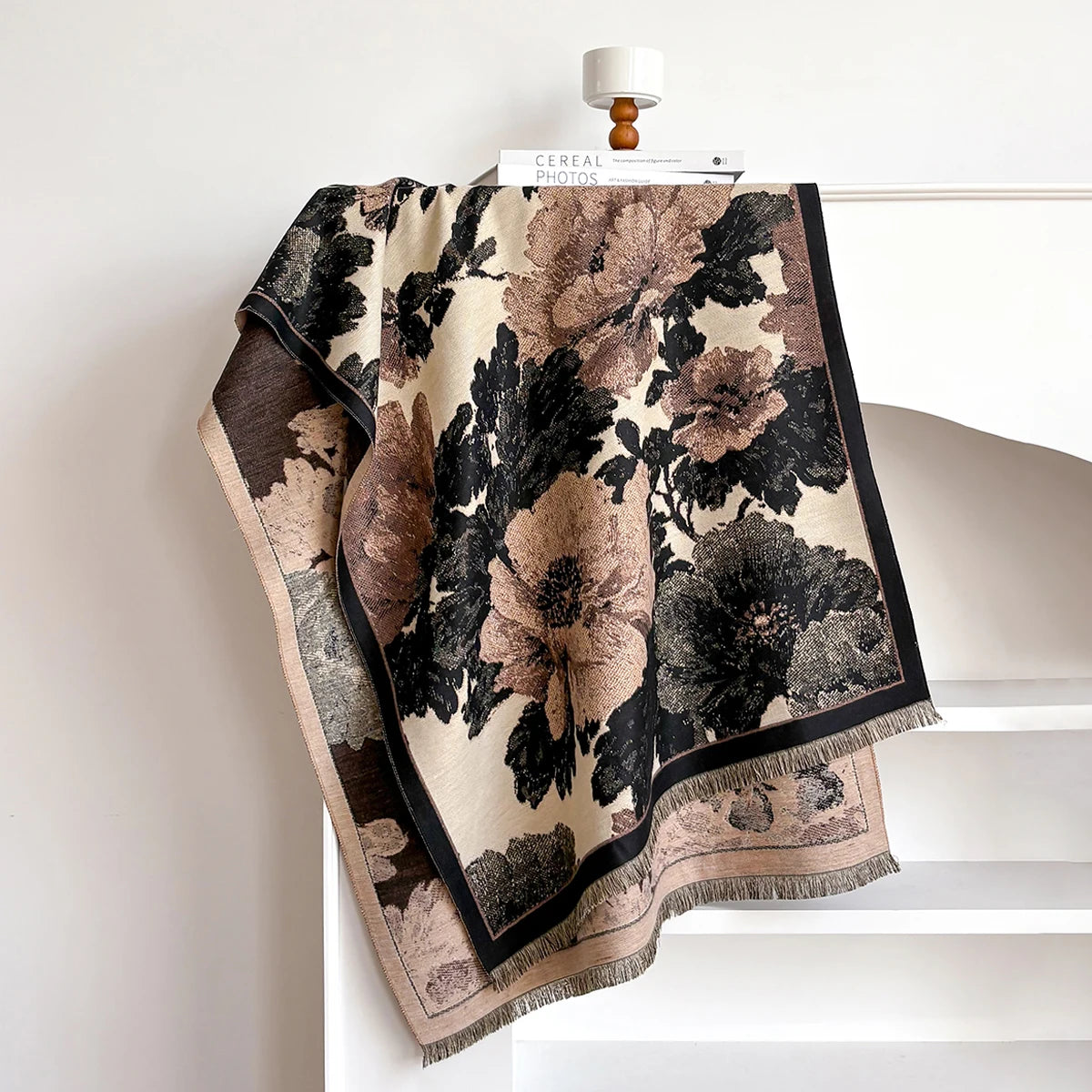 Floral patterned blanket draped over a chair against a white wall