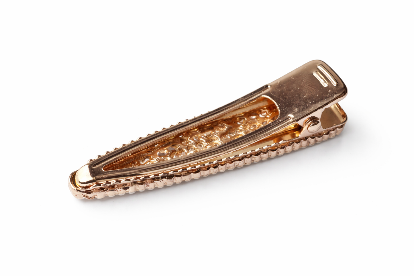 Rose gold hair clip with textured design on a white background
