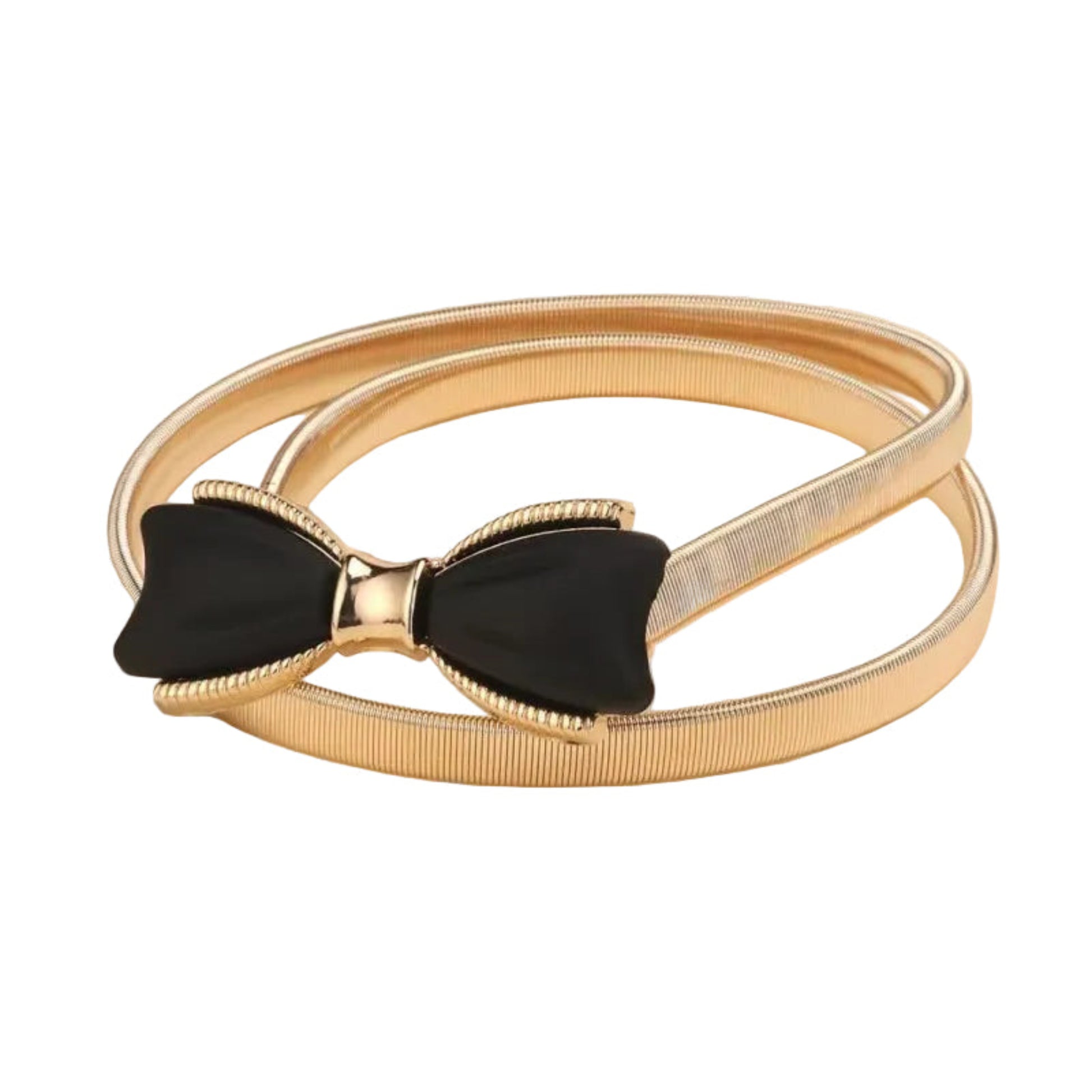 A slim metallic gold bangle bracelet with a textured ribbed band and a central black bow-shaped accent outlined in gold, shown on a warm beige background.