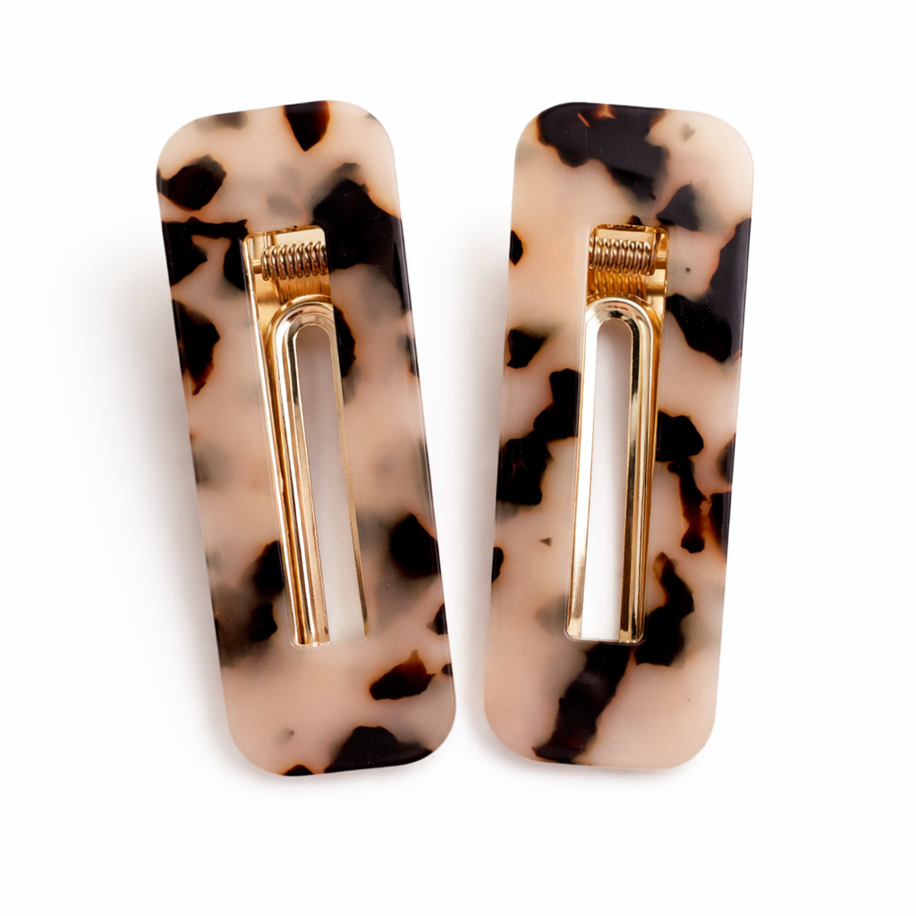 Pair of earrings with tortoiseshell pattern and gold accents on a white background