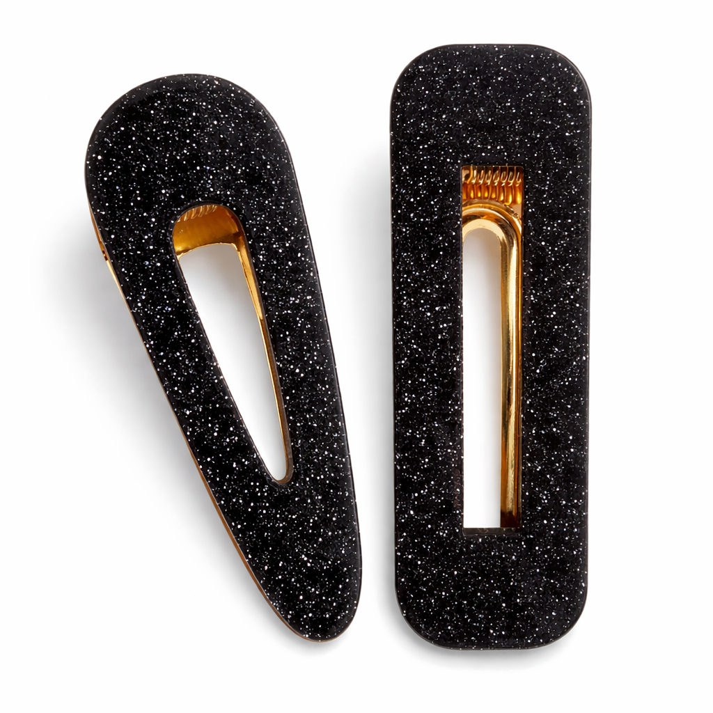 Black glittery hair clips with gold centers on a white background