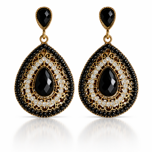 Pair of gold and black teardrop earrings on a white background