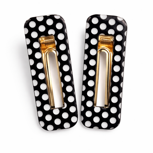 Pair of hair clips with black and white polka dot design on a white background
