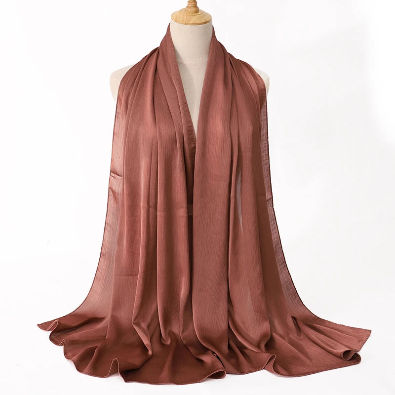 Brown scarf draped over a mannequin on a white background