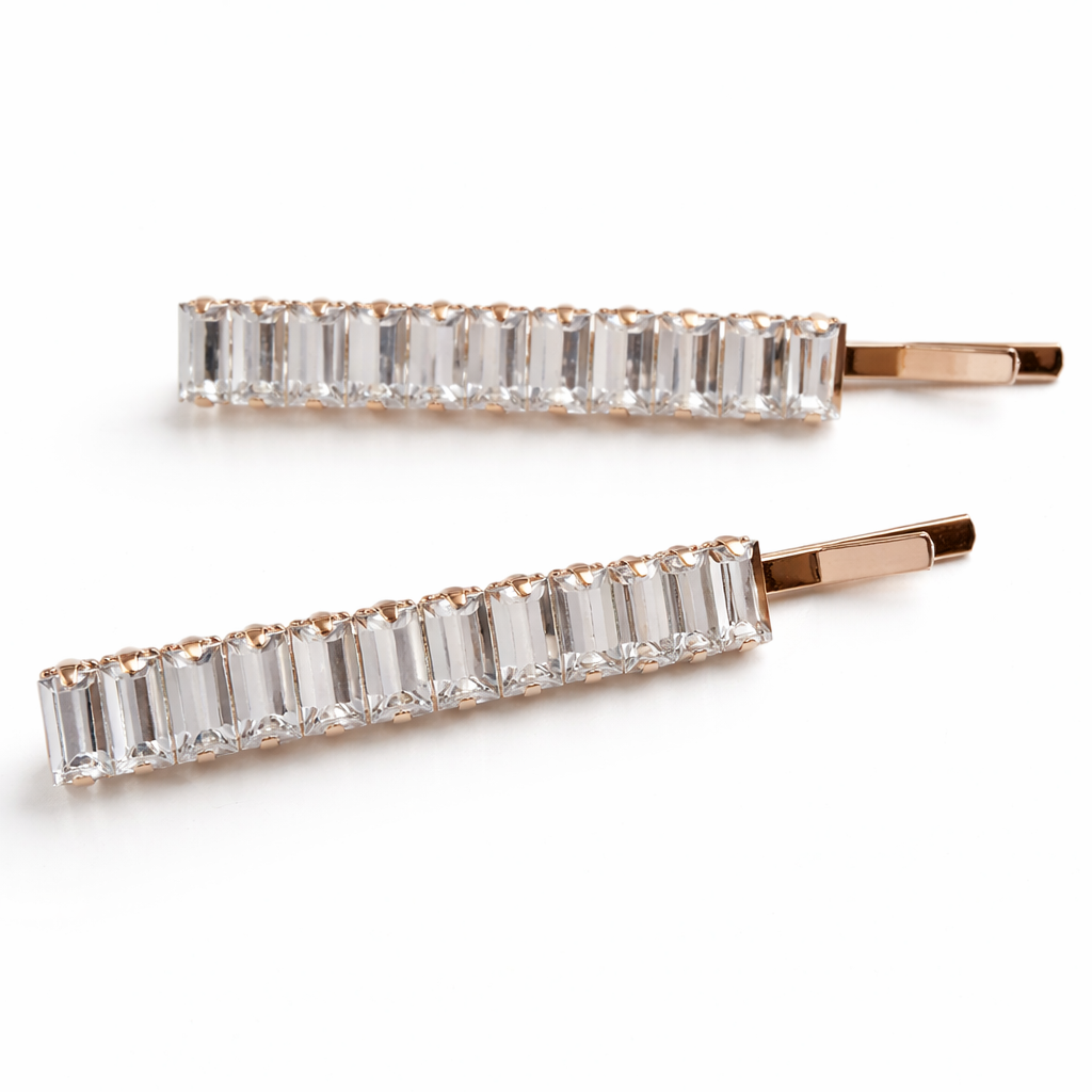 Two gold hair pins with clear gemstones on a white background