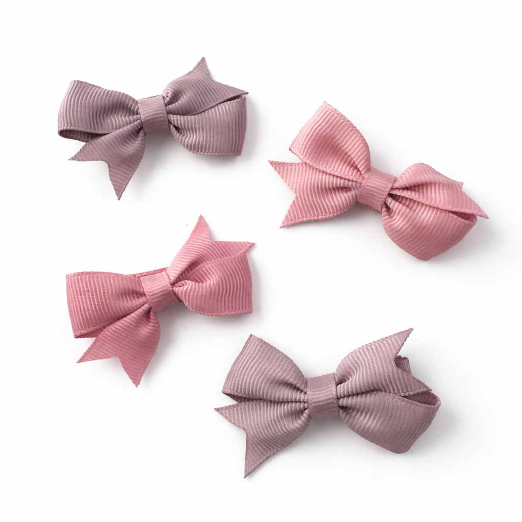 Four pink hair bows on a white background