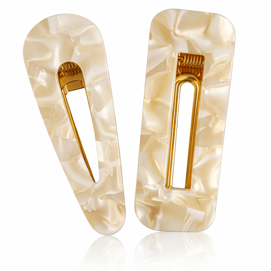 Pair of beige hair clips with gold accents on a white background