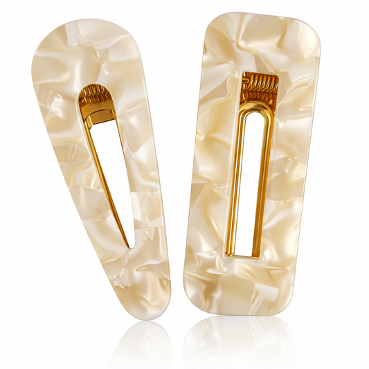 Pair of beige hair clips with gold accents on a white background