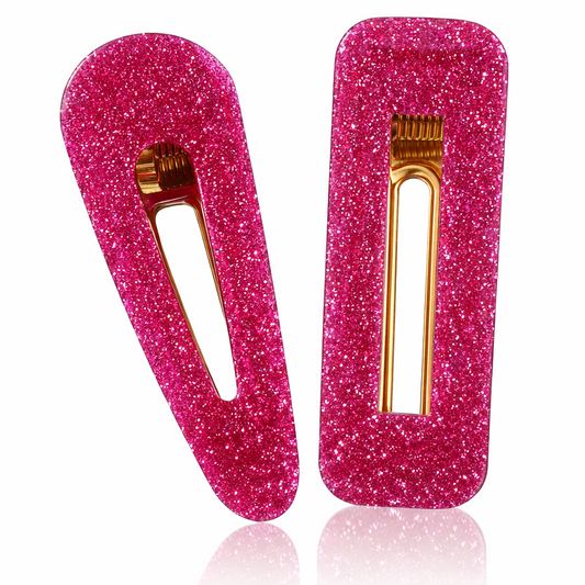 Two pink glitter hair clips with gold hardware on a white background