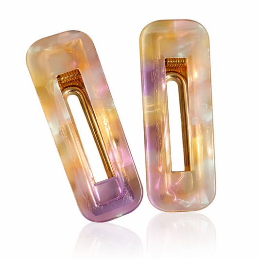 Two iridescent hair clips on a white background