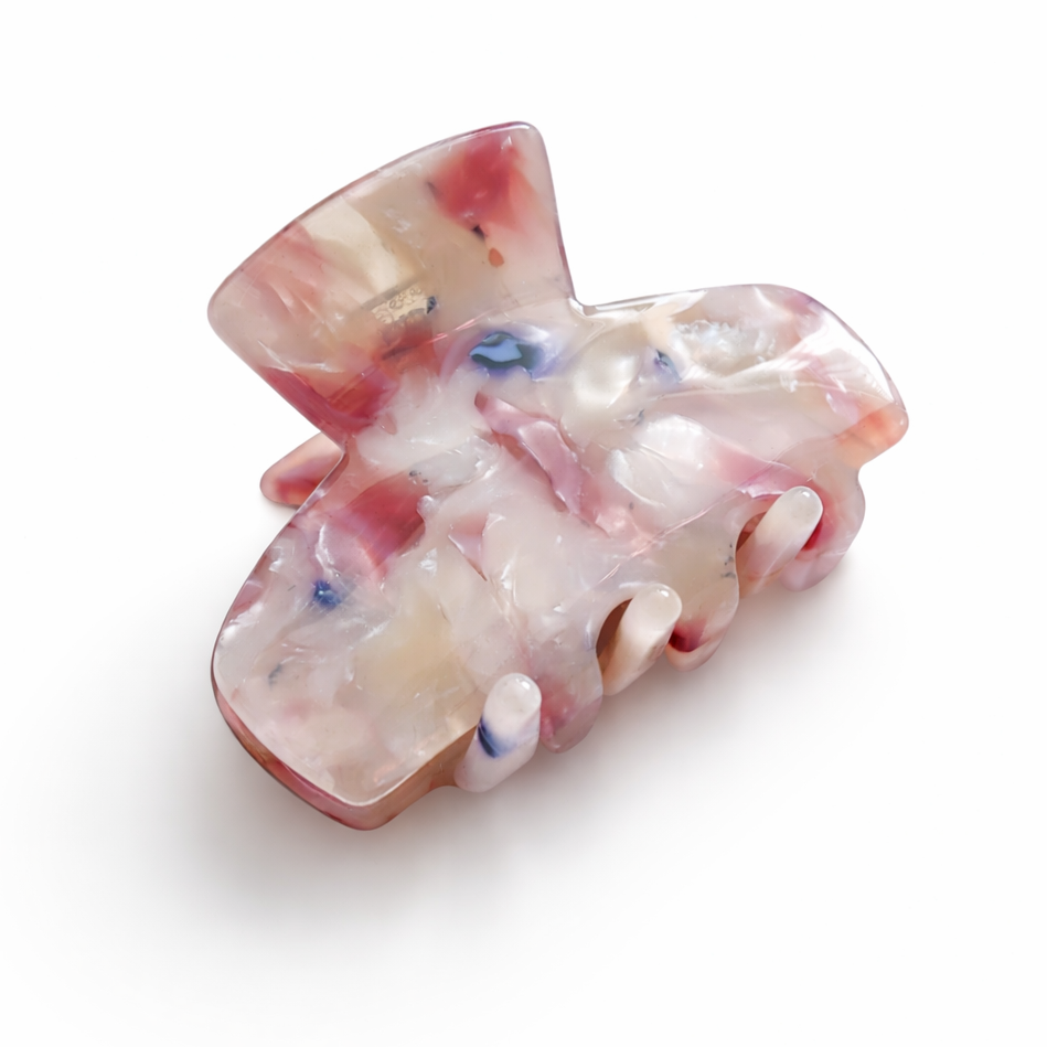 Marbled pink and white hair clip on a white background