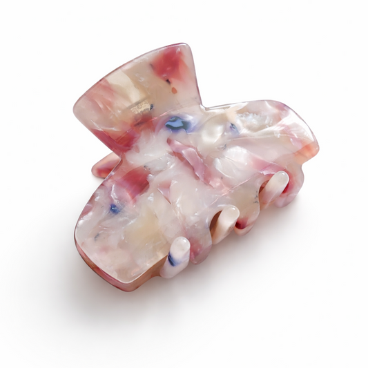 Marbled pink and white hair clip on a white background
