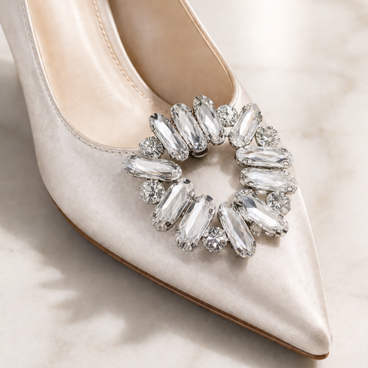 White high-heeled shoe with a decorative crystal embellishment on a light background
