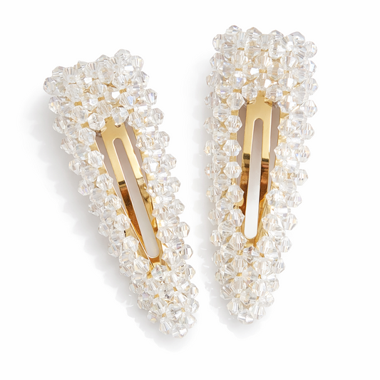 Pearl-framed hair clips with gold centers on a white background