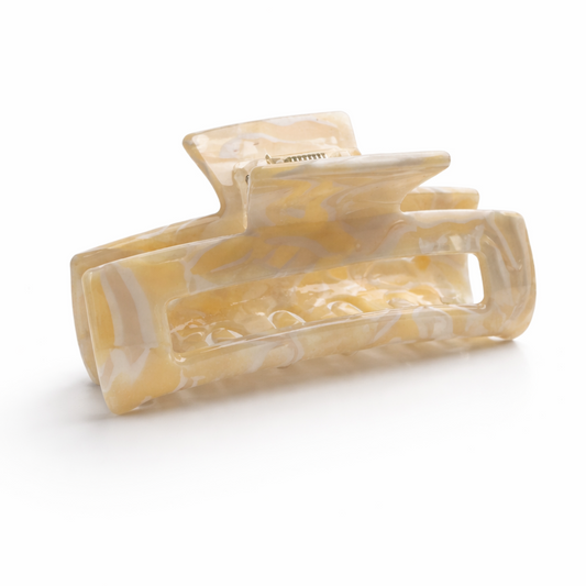 Beige hair clip with a marble pattern on a white background