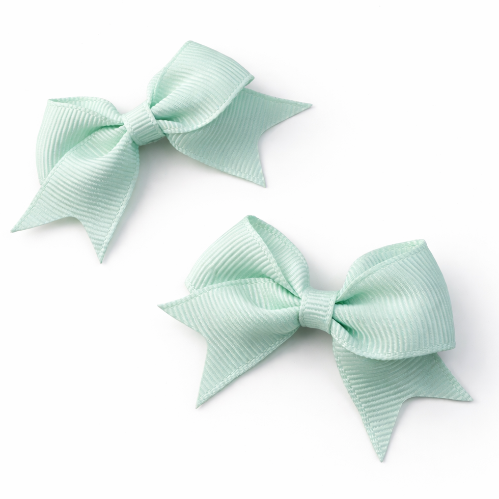 Two mint green hair bows on a white background