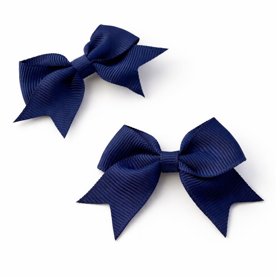 Two navy blue hair bows on a white background