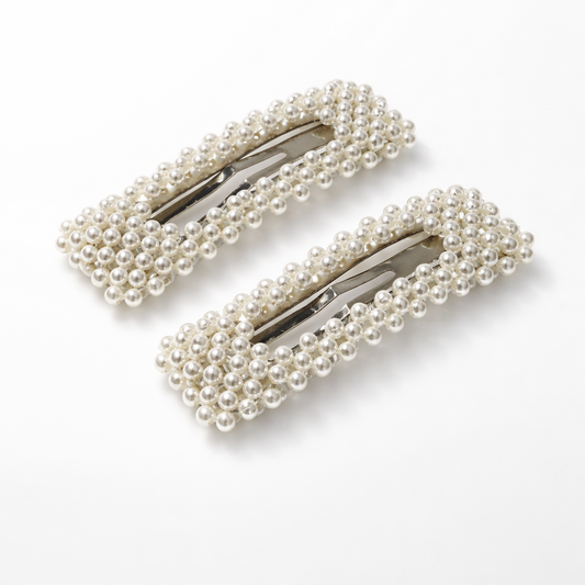 Two pearl hair clips on a white background
