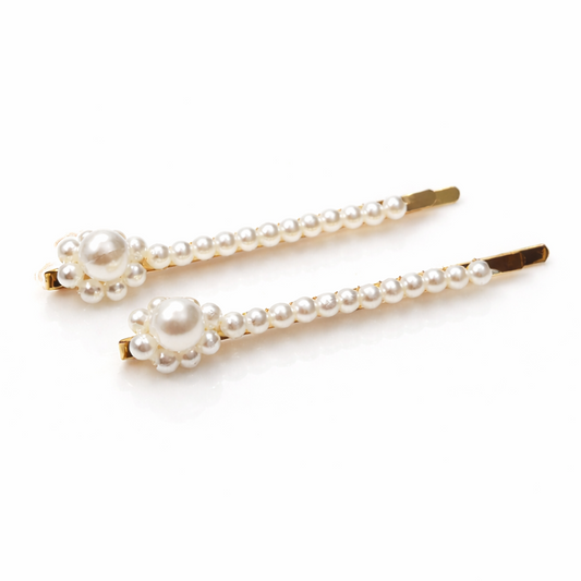 Two pearl hairpins on a white background
