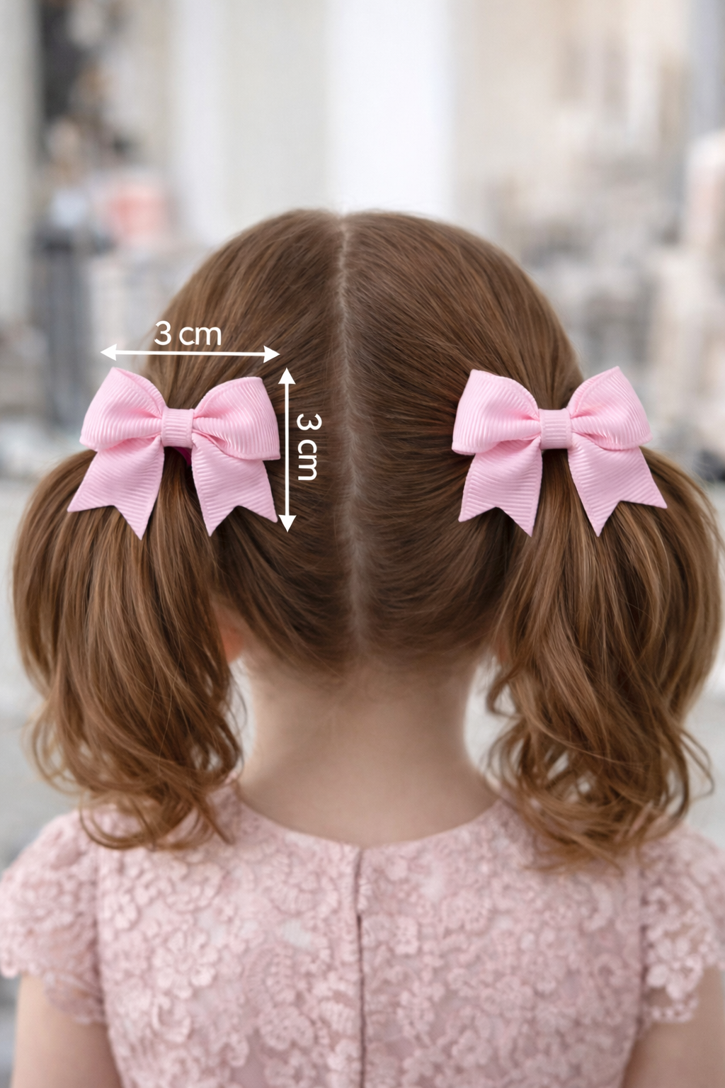 Child with pigtails wearing pink hair bows, with measurements indicated.