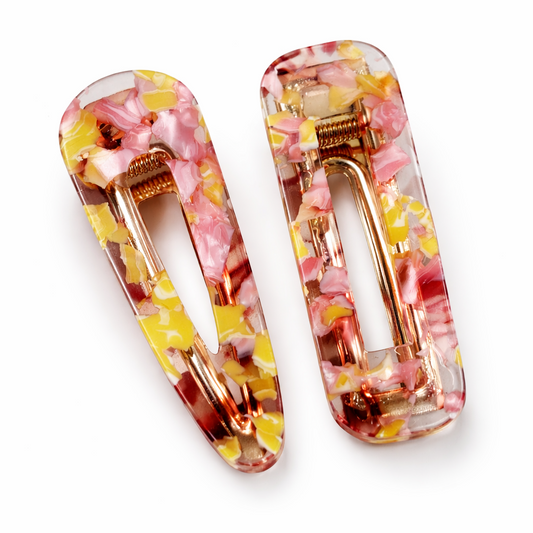 Two floral patterned hair clips on a white background