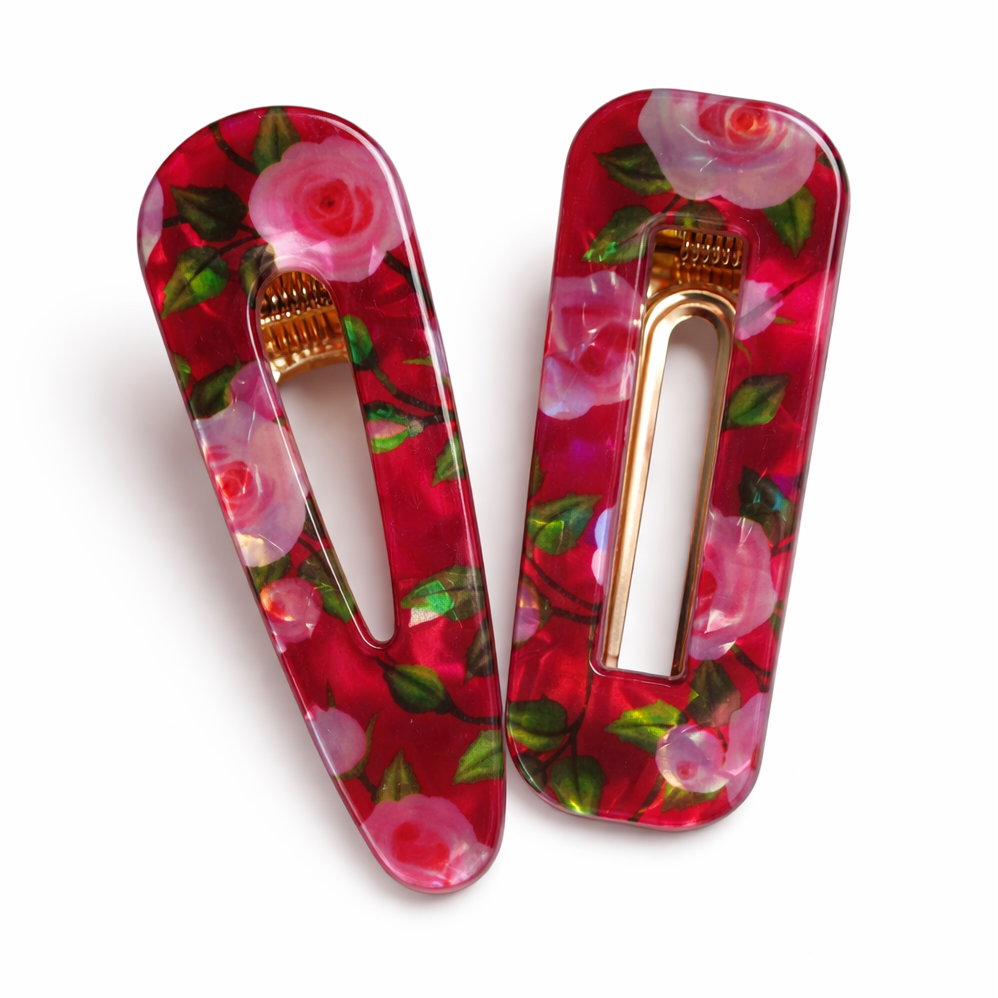 Two floral hair clips on a white background
