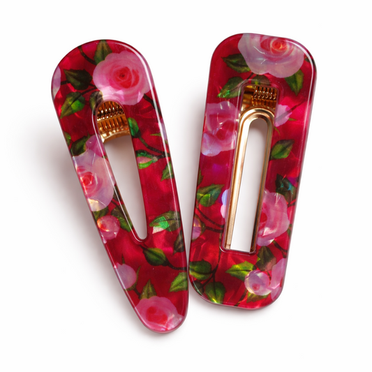 Two floral hair clips on a white background