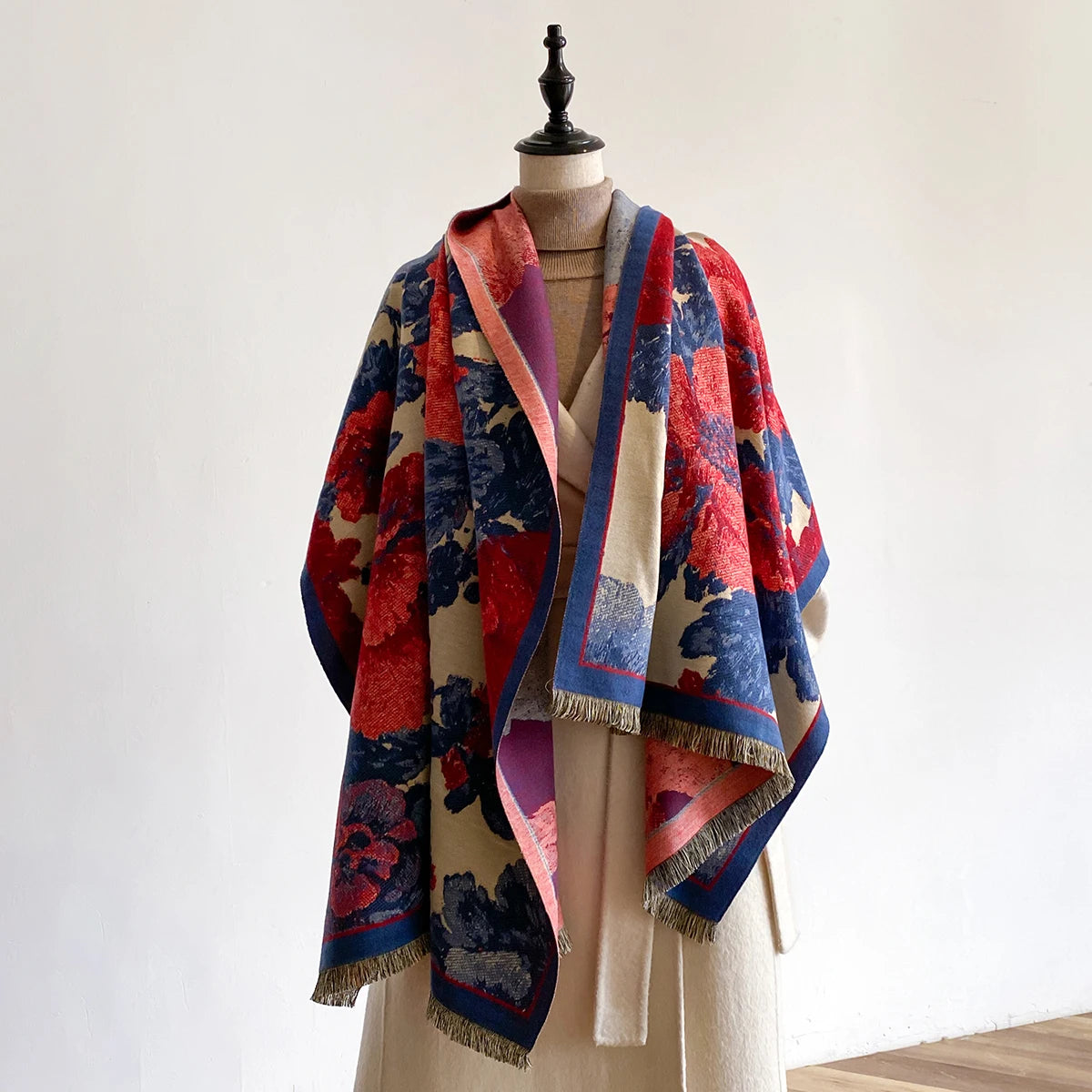 Colorful patterned shawl draped over a mannequin against a plain background