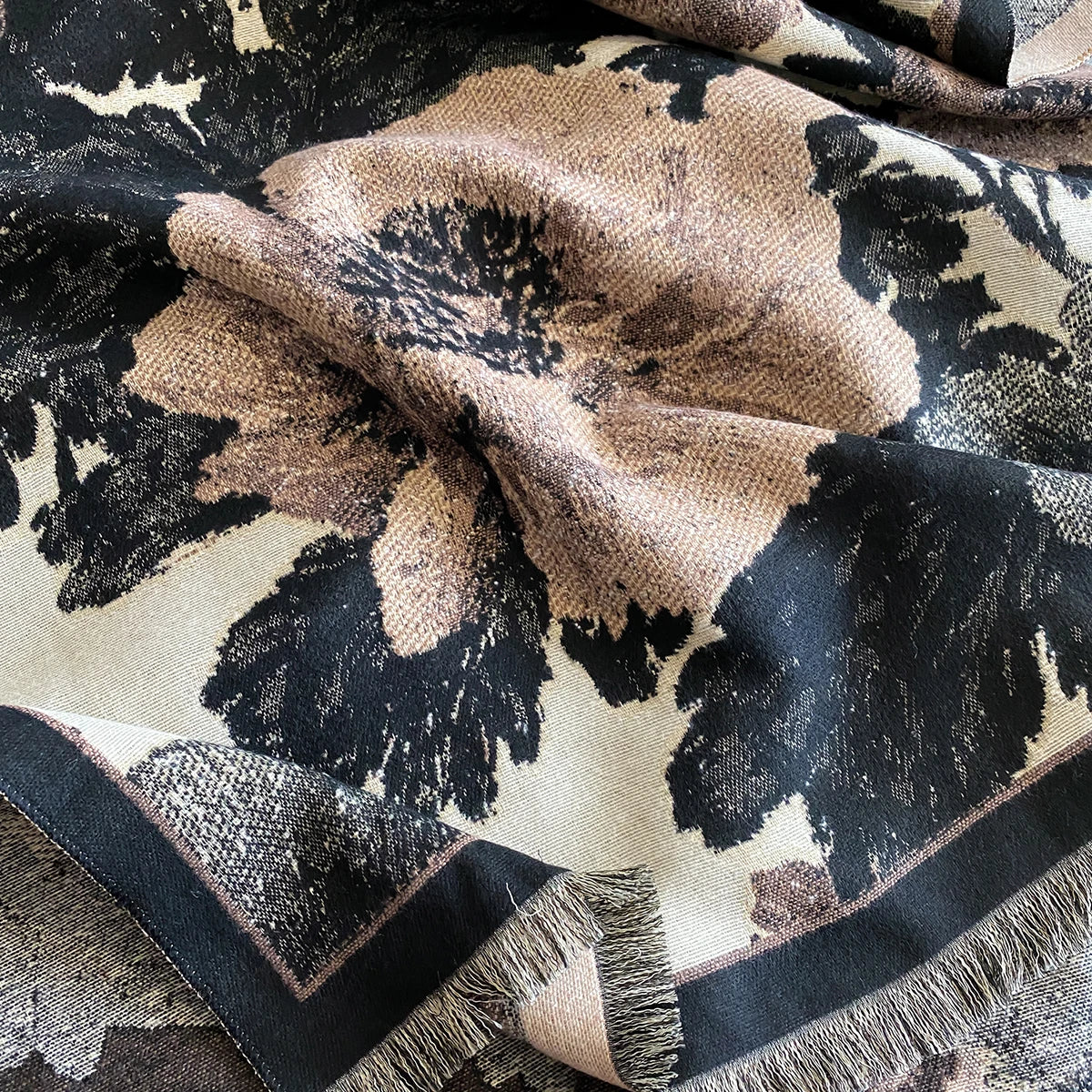 Close-up of a patterned fabric with black, beige, and white colors.