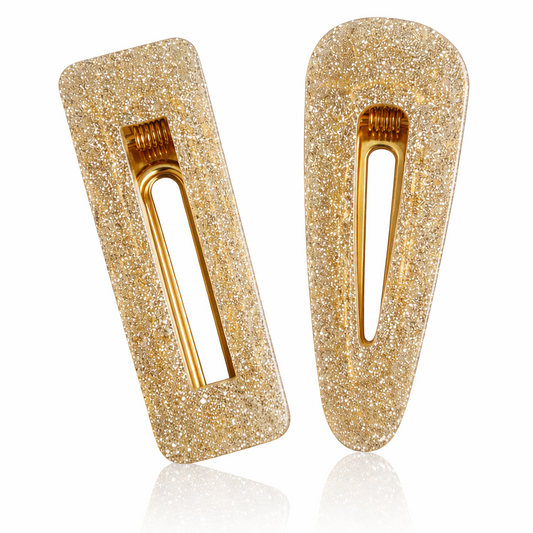 Two gold glittery hair clips on a white background
