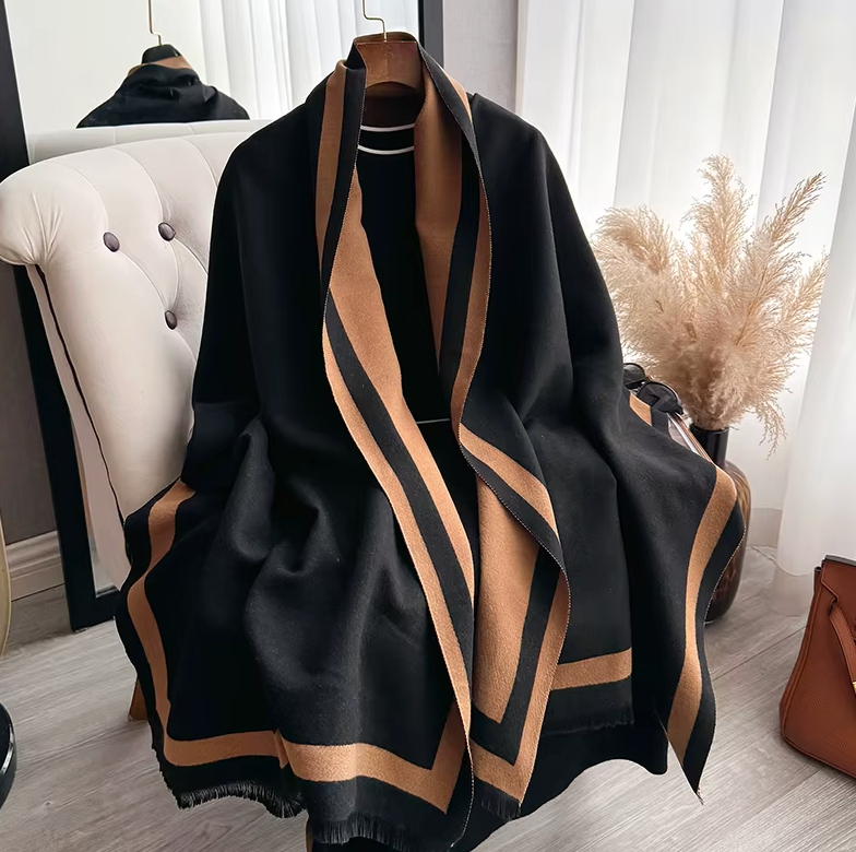 Black and beige striped scarf on a hanger with a blurred indoor background