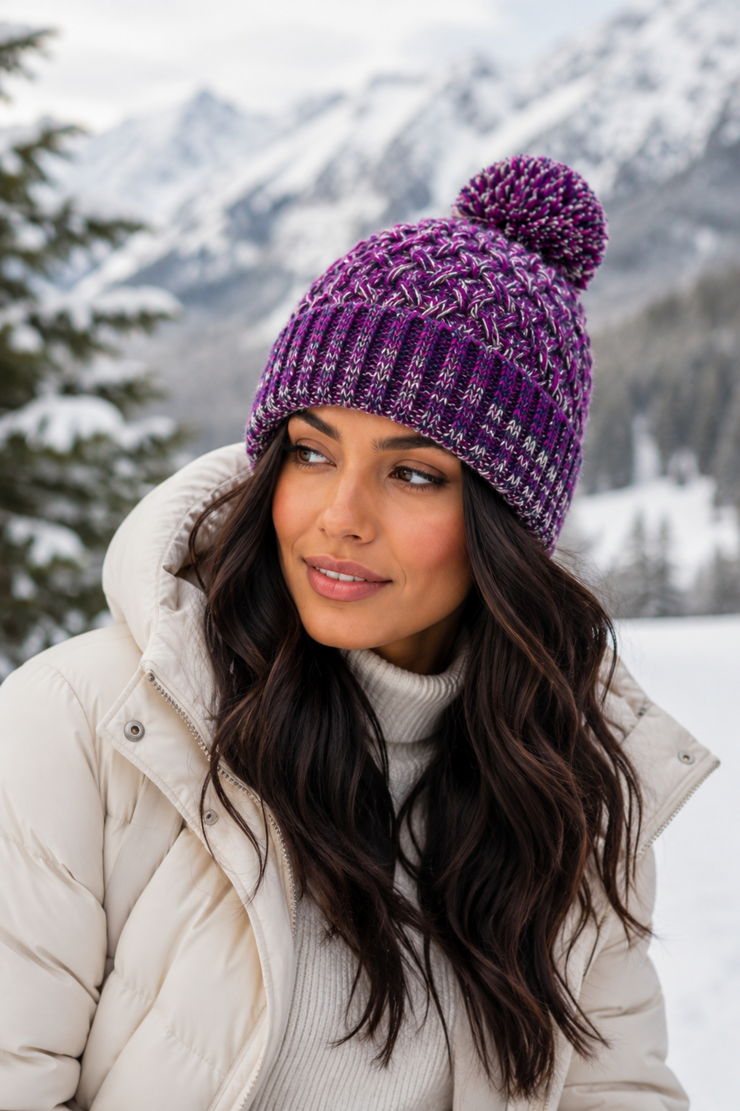 Woman wearing a purple knit beanie with a pom-pom in a snowy mountain landscape