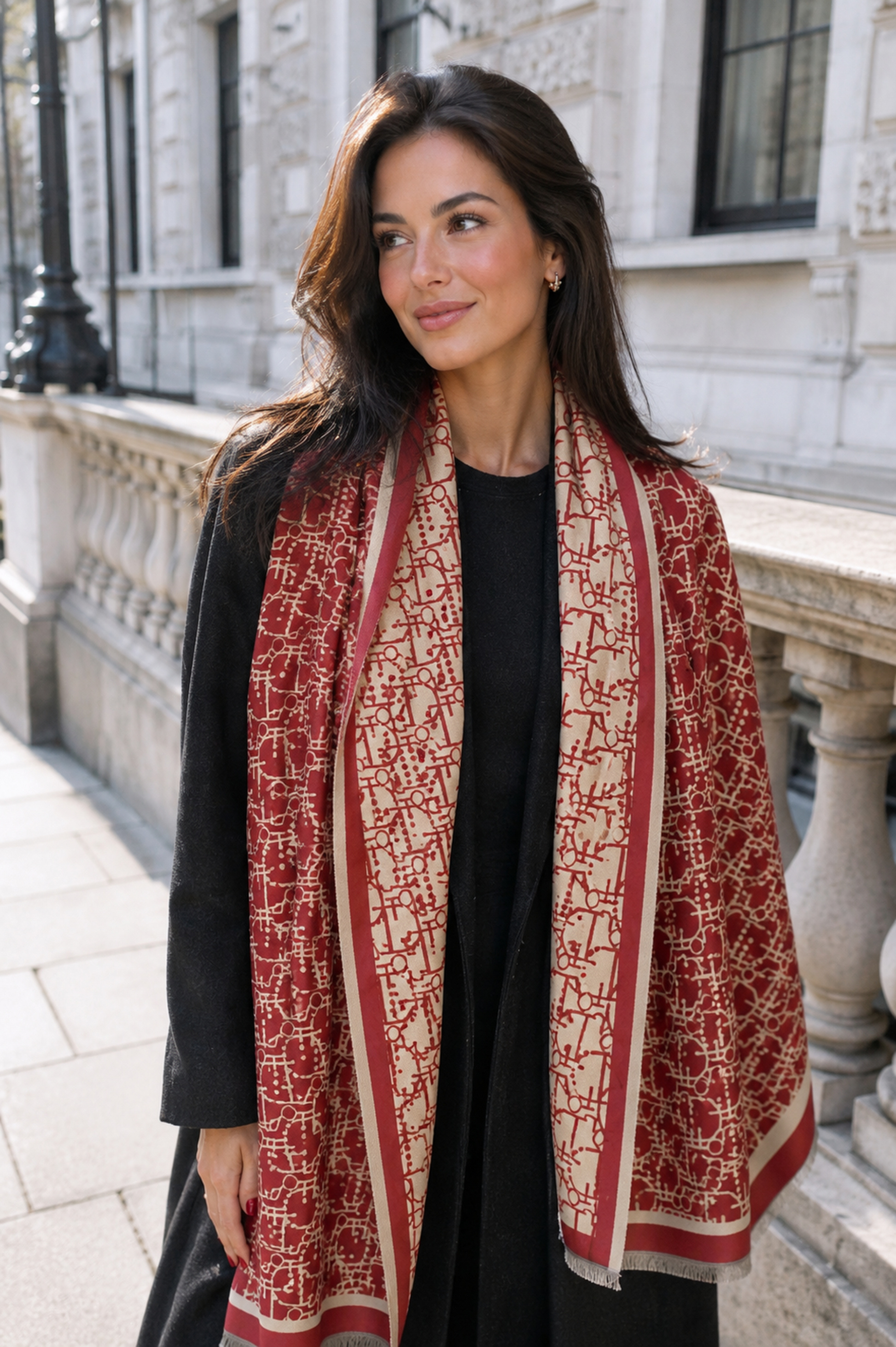 Woman wearing a red and beige patterned scarf in an urban setting