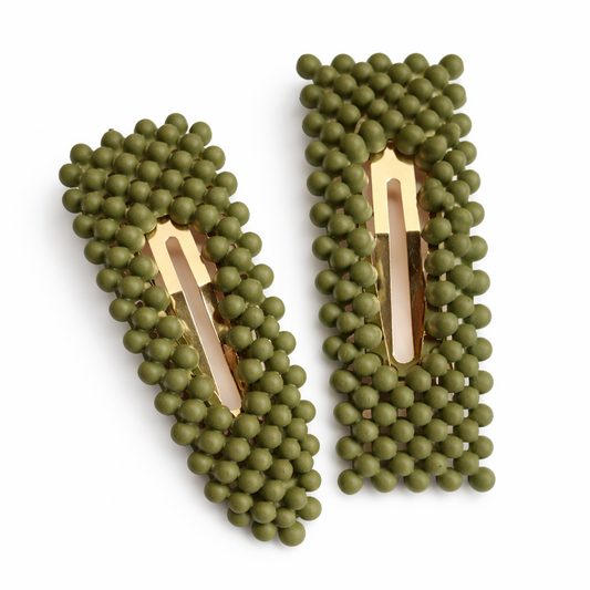 Pair of green beaded hair clips on a white background
