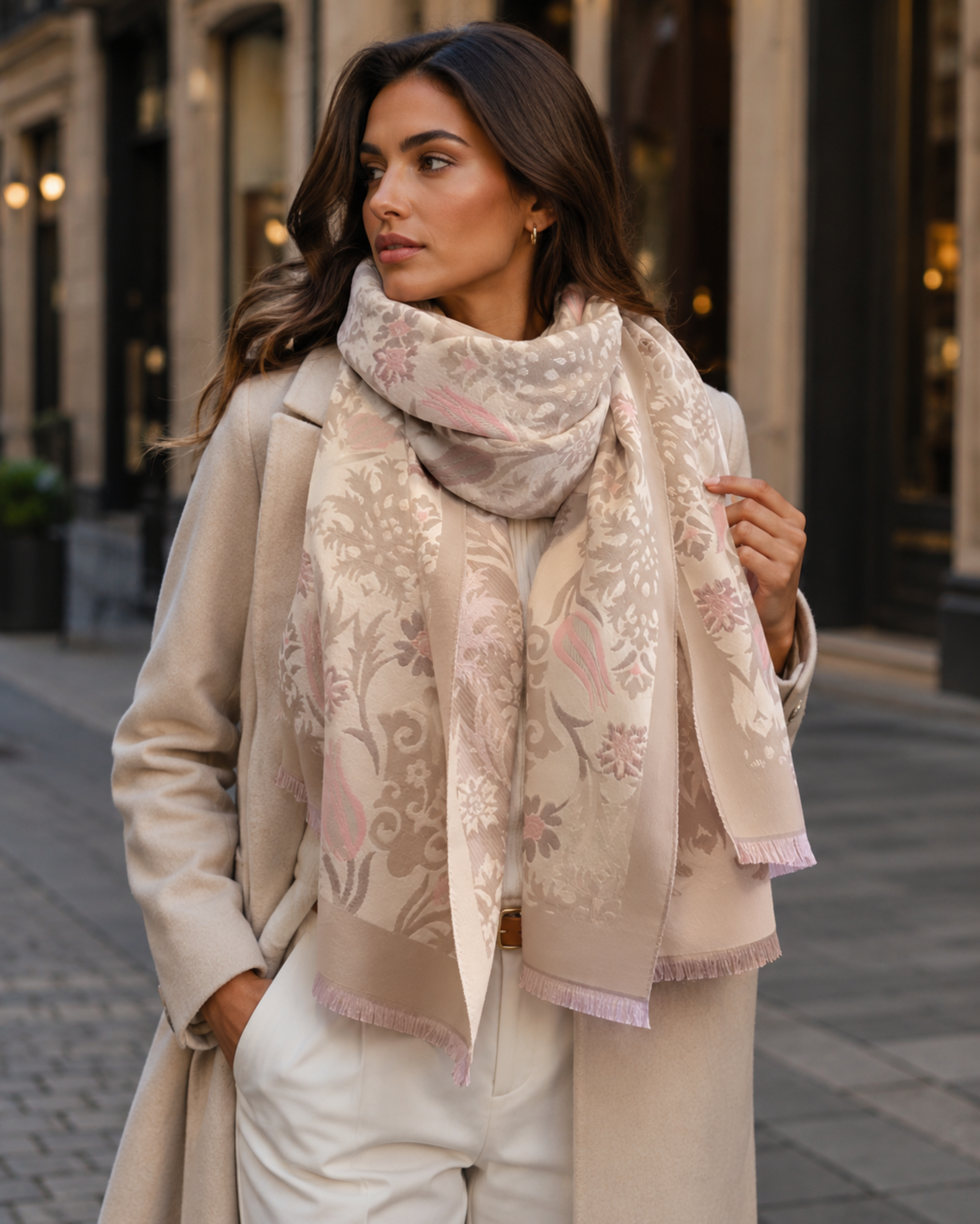 Woman wearing a floral scarf and beige coat on a city street
