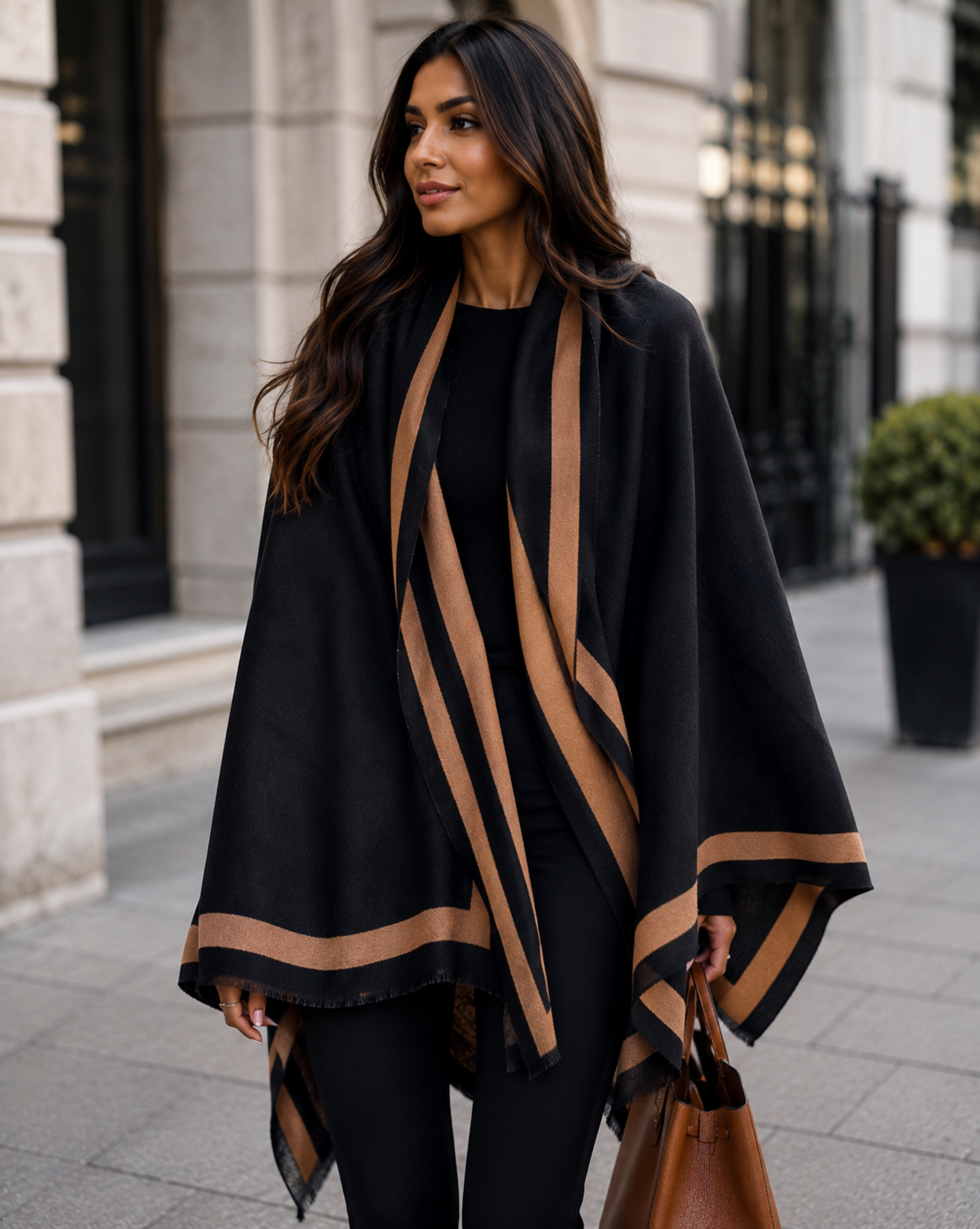 Woman wearing a black and brown striped poncho in an urban setting