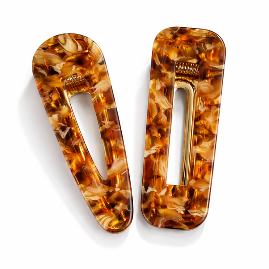 Two tortoiseshell hair clips on a white background