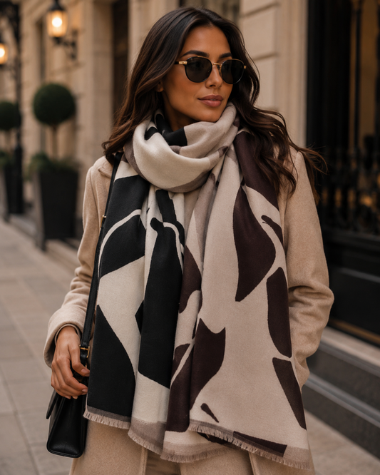 Woman wearing a patterned scarf and sunglasses on a city street.