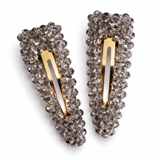 Pair of decorative hair clips with crystal embellishments on a white background