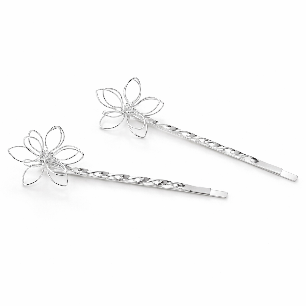 Two silver flower-shaped hairpins on a white background