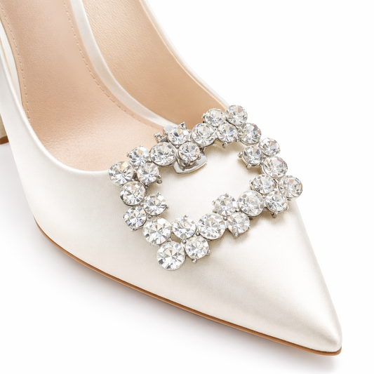 White high-heeled shoe with a decorative crystal embellishment on a white background