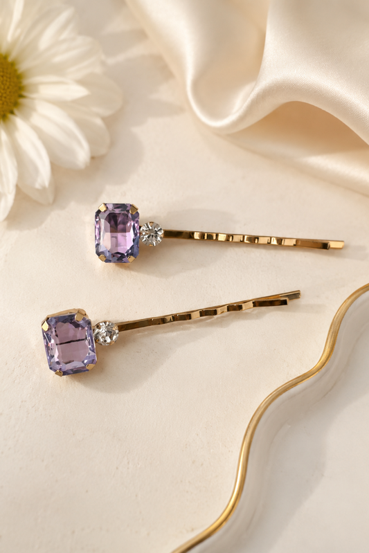 Set of two lilac crystal and rhinestone gold hair slides for women, featuring rectangular lavender gemstones on slim gold bobby pins, elegant hair accessories for weddings, bridesmaids, parties and occasion wear.