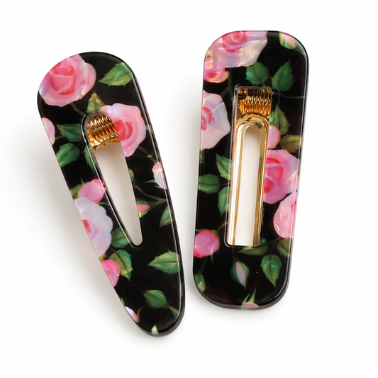 Two floral hair clips on a white background