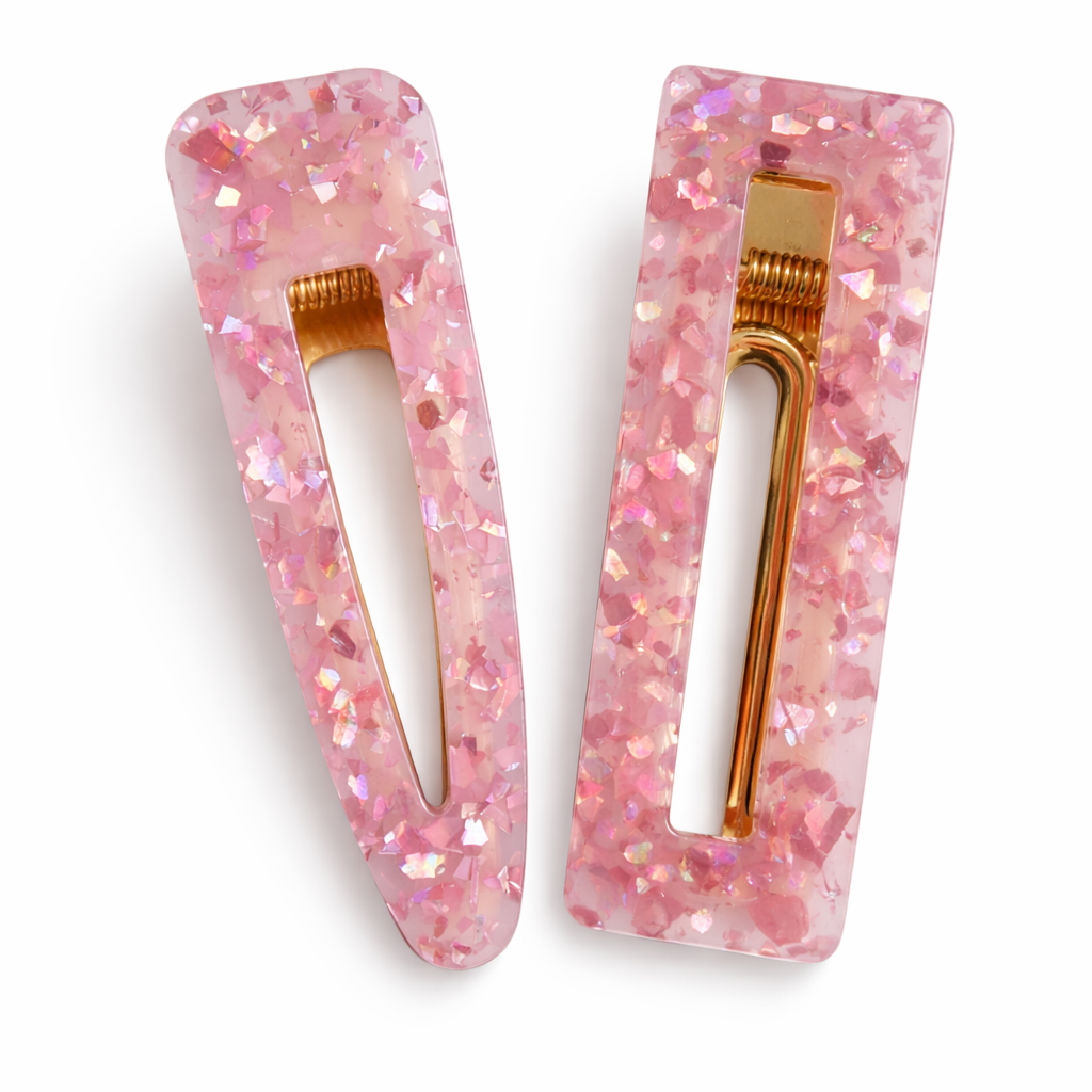 Two pink glitter hair clips with gold centers on a white background