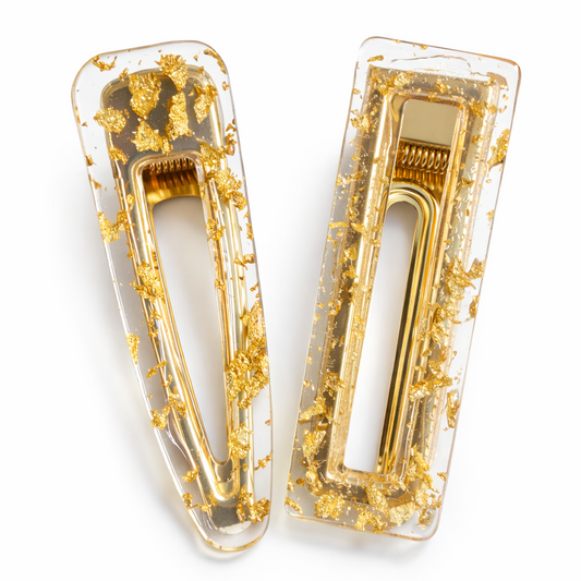 Gold and clear hair clips on a white background