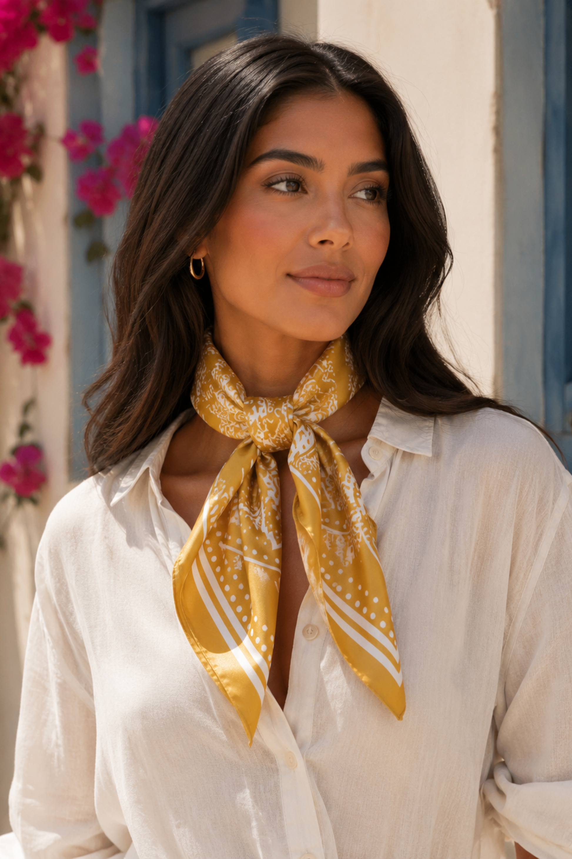 Woman wearing a yellow patterned scarf around her neck with a floral and architectural background