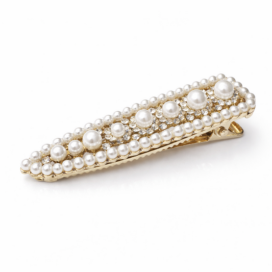 Gold hair clip with pearls on a white background