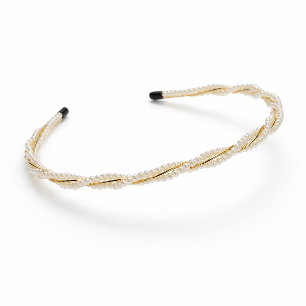 Gold headband with black ends on a white background