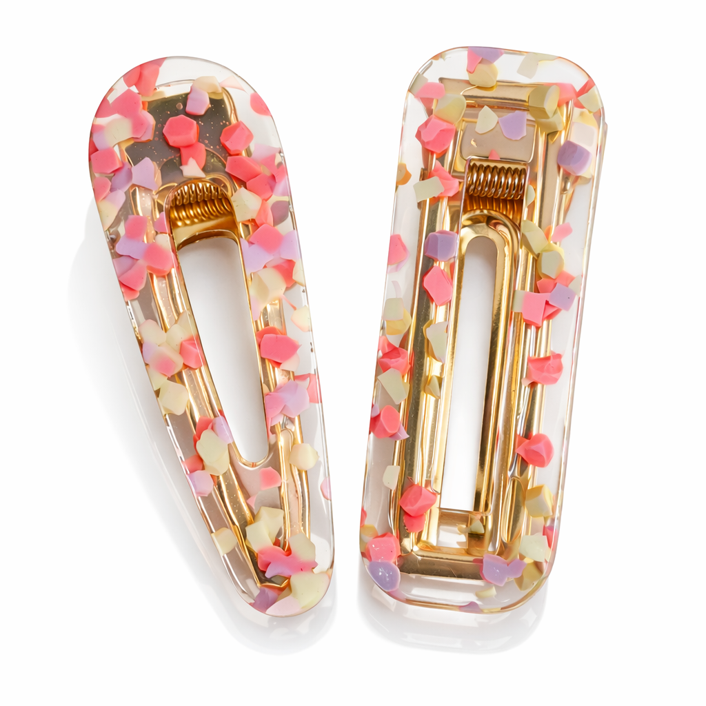 Two colorful hair clips with gold accents on a white background