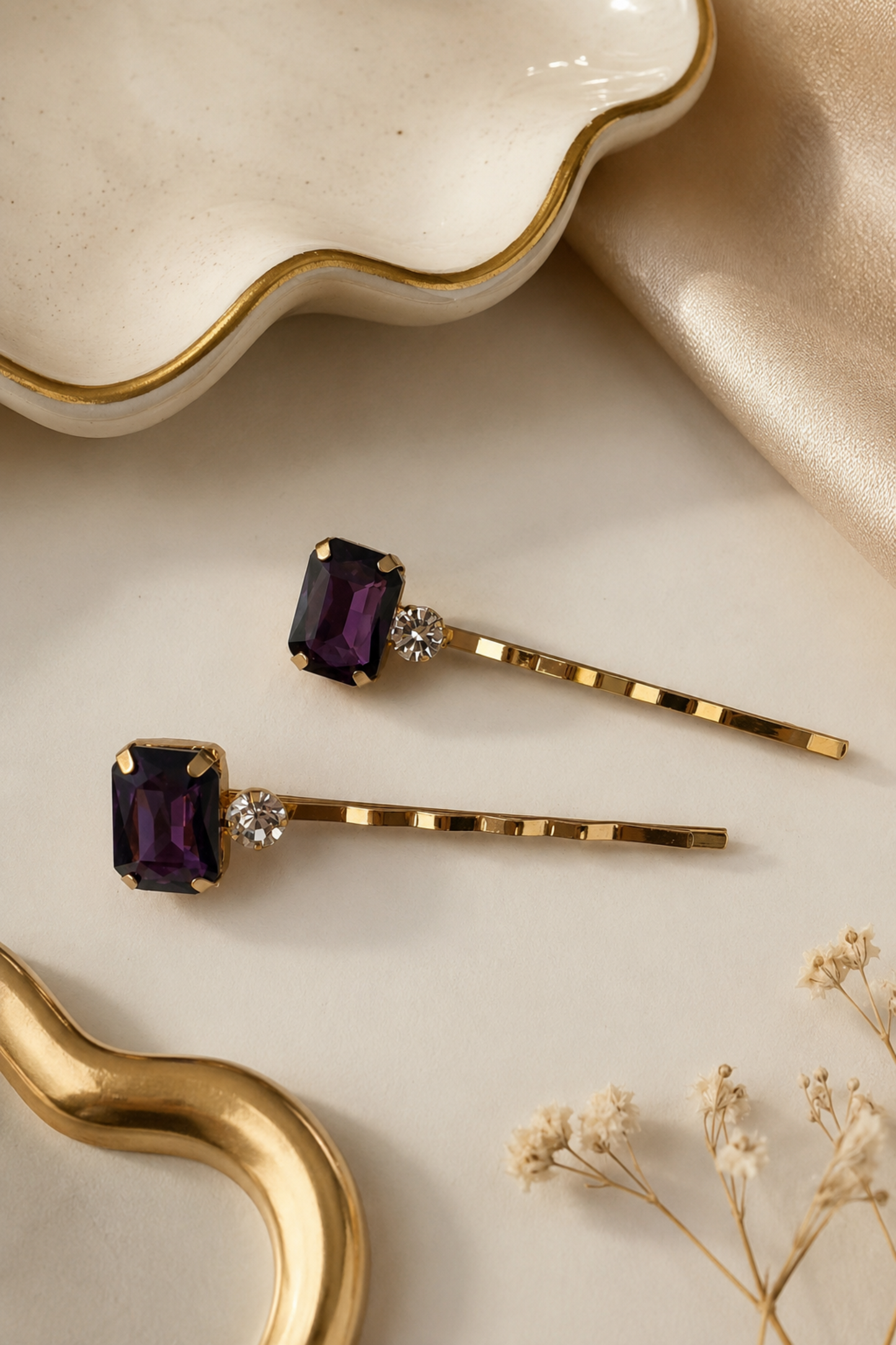 Set of two purple crystal and rhinestone gold hair slides for women, featuring rectangular amethyst-style gemstones on slim gold bobby pins, elegant statement hair accessories for weddings, parties and evening outfits.